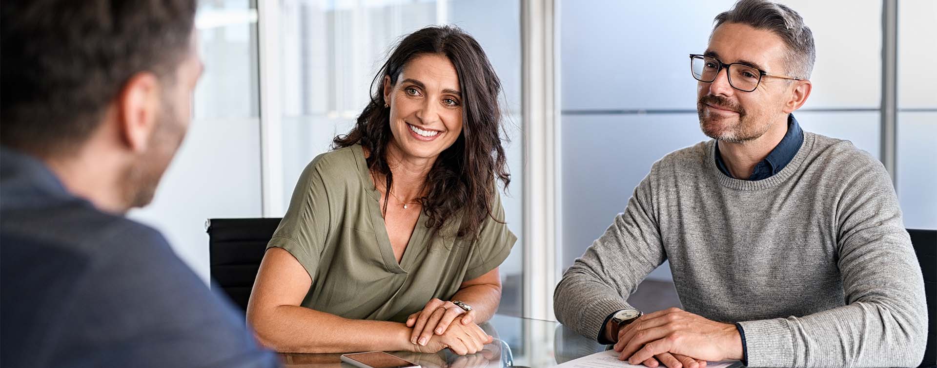 Smiling couple at a table listening to an expert
