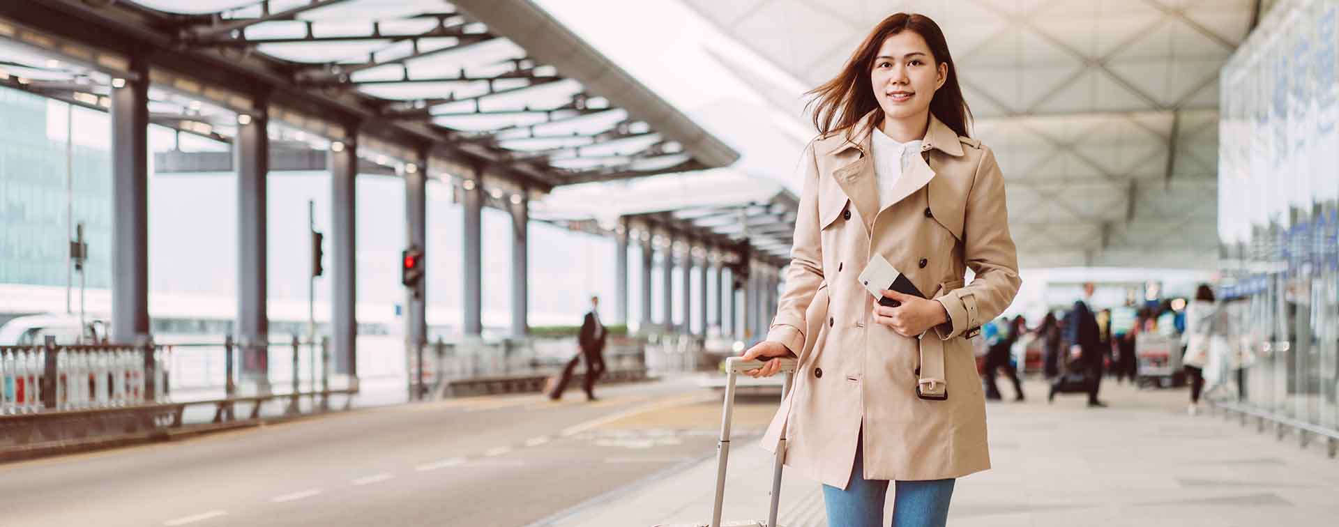 Woman walking through airport holding passport