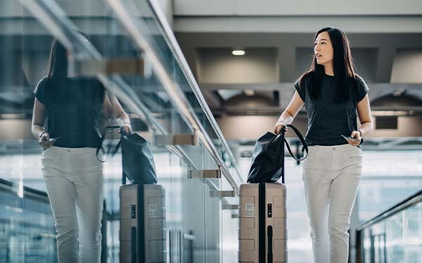 Woman with luggage walking through an airport terminal
