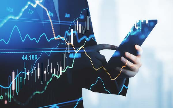 Fluctating charts superimposed over a person typing on a cellphone