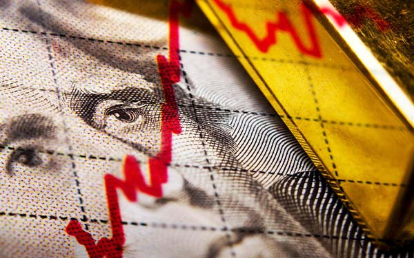 Close up of a dollar banknote and gold ingot and a financial chart
