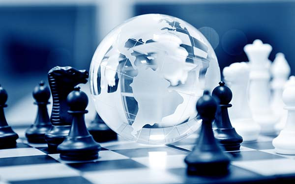 Crystal globe and chess pieces on chessboard