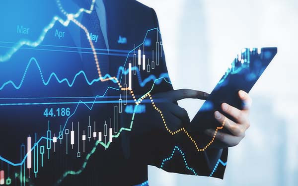 Trading and investment concept trader silhouette with digital tablet and virtual screen with financial chart graphs and candlestick