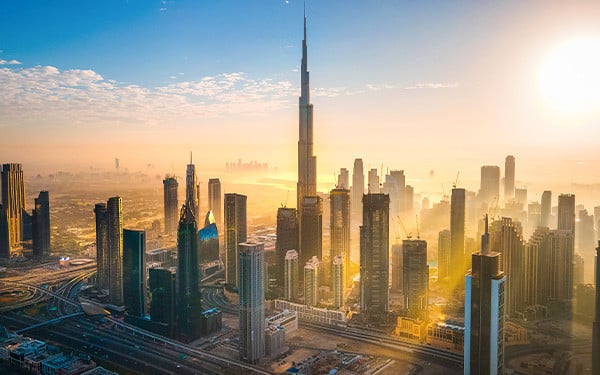 Skyline in Dubai, UAE, illuminated by a glowing sun