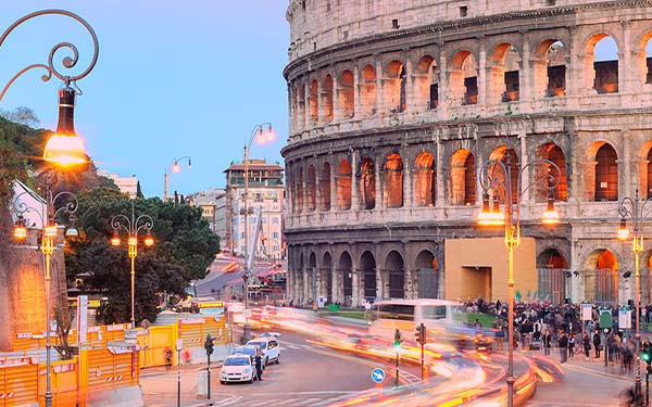 Colosseum, Rome, Italy, on sunset with timelapse of traffic at its base
